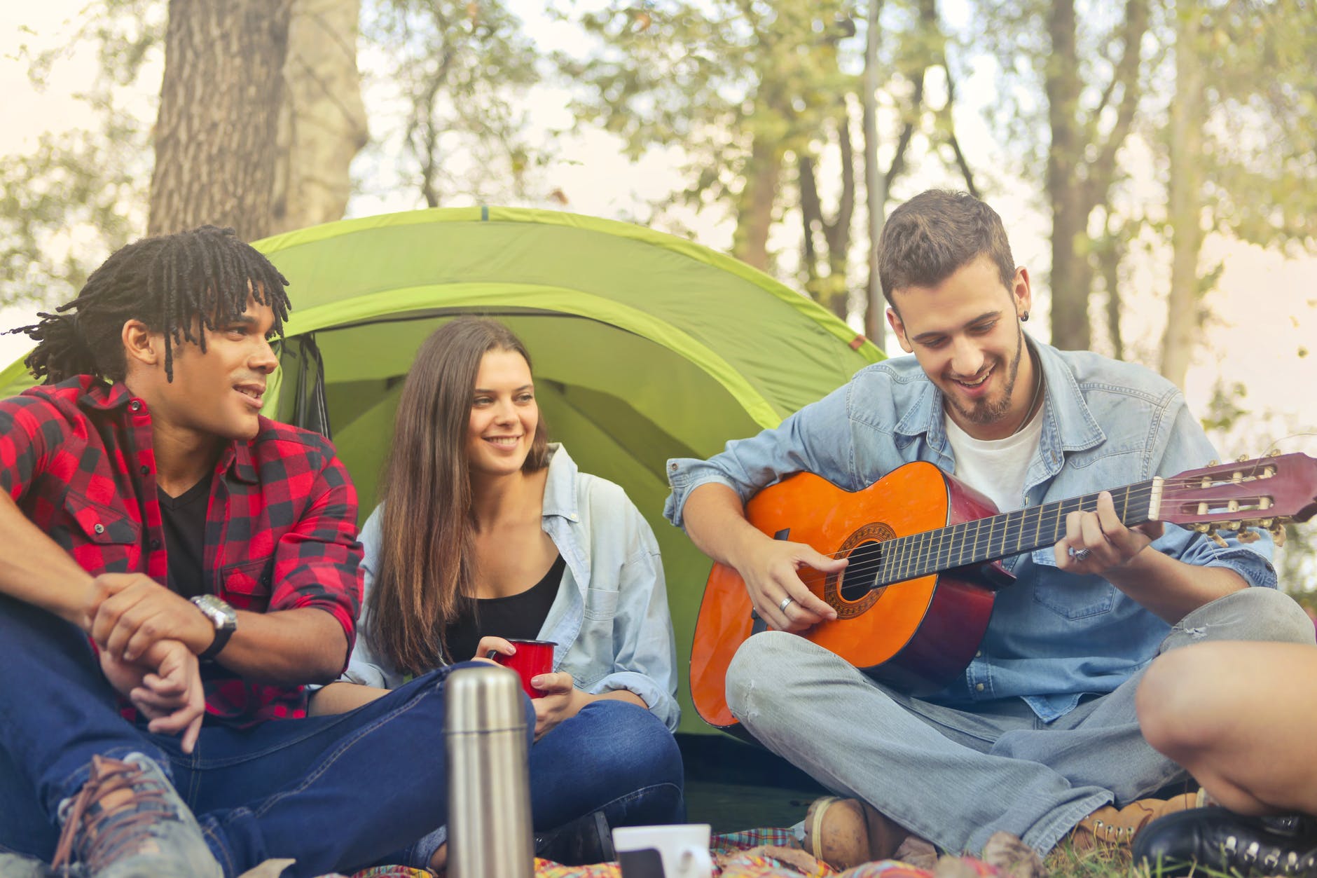 man in denim long sleeves playing acoustic guitar